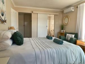 1 dormitorio con 1 cama blanca grande con almohadas azules en Waterfront 2 Bedroom Apartment, en Richards Bay