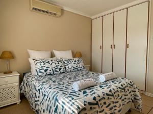 1 dormitorio con 1 cama con sábanas azules y blancas en Waterfront 2 Bedroom Apartment, en Richards Bay