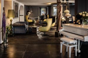 a living room with a white piano and chairs at Alpin Garden Luxury Maison & SPA - Adults Retreat in Ortisei +111 photos