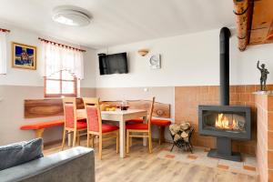a living room with a fireplace and a table and chairs at Vineyard Cottage Tramte in Škocjan