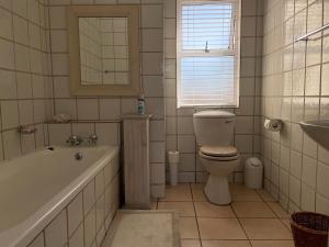 a bathroom with a tub and a toilet and a sink at Waterfront 2 Bedroom Apartment in Richards Bay