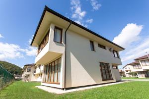 a white house with a black roof at Malak Resort Sarajevo in Sarajevo