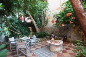 a patio with two tables and chairs and trees at Beautiful Traditional House in Lefkada in Lefkada Town