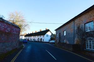 uma rua vazia numa pequena cidade com edifícios em Thatched Cottage, beautiful village near the sea em Otterton