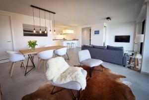 a living room with a table and chairs and a couch at Appartement aan jachthaven met zicht op Veerse meer in Arnemuiden