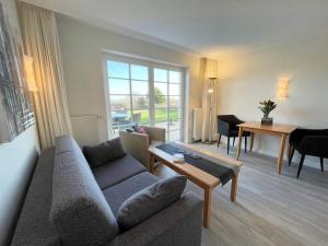 a living room with a couch and a table at Haus am Wattenmeer Watt n Idyll in Rantum