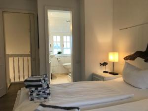 een slaapkamer met een wit bed en een badkamer bij Robin Hood in Kampen
