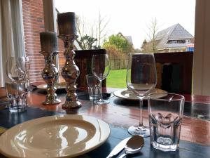 a table with wine glasses and plates on it at Wiesenhüs in Tinnum