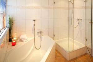 a white bathroom with a tub and a shower at Theodor Heuss in Westerland