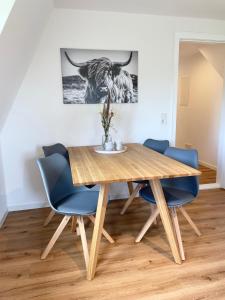 ArchsumにあるWiesensichtのダイニングルーム(木製テーブル、青い椅子付)