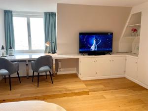 a living room with a desk with a television on it at Norderhof Kliffsand 19 in Kampen