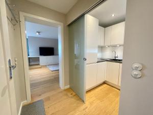 una puerta abierta a una cocina con armarios blancos en Norderhof Kliffsand 19, en Kampen
