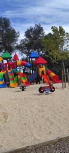 a playground with colorful playground equipment in the sand at Baia 1 in Drammont