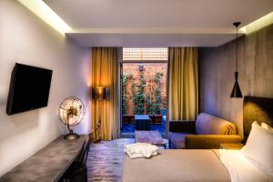 a hotel room with a large bed and a television at 360 Degrees in Athens