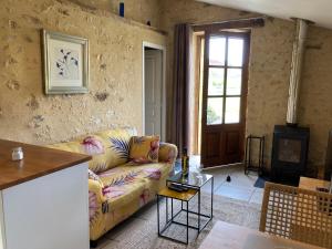 un soggiorno con un divano e una TV di Les Roses a Barjou