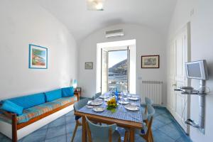 uma sala de estar com uma mesa e um sofá azul em Dolce Vita B em Amalfi