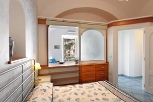 una camera con un letto e due finestre e uno specchio di Dolce Vita B ad Amalfi