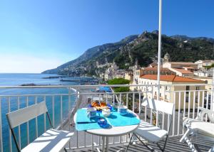 a table on a balcony with a view of the ocean at Dolce Vita B in Amalfi