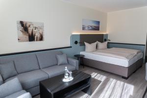 ein Hotelzimmer mit einem Bett und einer Couch in der Unterkunft TIDE Hotel in Wilhelmshaven + 26 Fotos