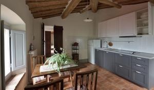 uma cozinha com uma mesa e algumas cadeiras e uma cozinha com em Il Maggese em Cortona