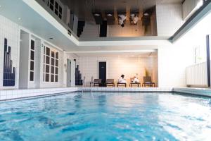 zwei Personen auf Stühlen neben einem Pool in der Unterkunft TIDE Hotel in Wilhelmshaven