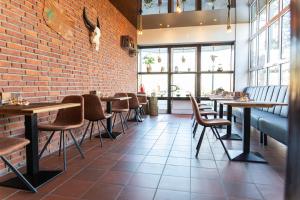 ein Restaurant mit Tischen und Stühlen und einer Backsteinmauer in der Unterkunft TIDE Hotel in Wilhelmshaven