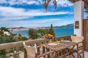 a table on a balcony with a view of the ocean at Koklas Studios in Lithakia