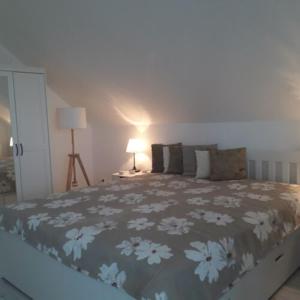 a bedroom with a large bed with a floral bedspread at Levendulas Apartman in Balatonalmádi