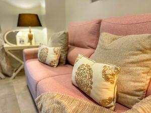a pink couch with pillows on it in a living room at Hostal Boutique Plaza Cantarero in Nerja