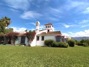 una casa blanca con una torre en la parte superior de un patio en La Imaroga, en Nerja