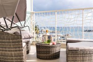 d'un balcon avec des chaises en osier et une vue sur l'océan. dans l'établissement Hotel Marinella, à Sanremo