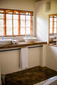 a bathroom with two sinks and two windows at Madi a Thavha Mountain Lodge in Louis Trichardt