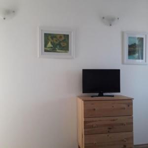 a television on a wooden dresser in a room at Levendulas Apartman in Balatonalmádi