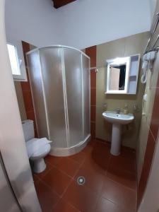 a bathroom with a shower and a toilet and a sink at Victory Apartments Hotel in Samothráki