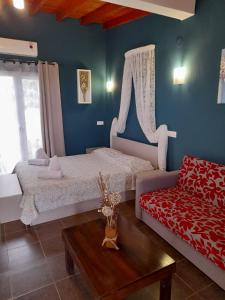 a bedroom with two beds and a couch at Victory Apartments Hotel in Samothr&aacute;ki