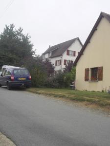 a car parked on the side of a road next to a house at Lenard Charles Bed & Breakfast in Juvigny-sous-Andaine