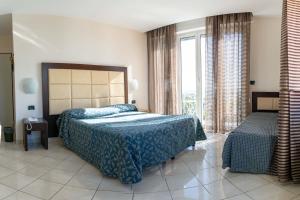 En eller flere senge i et værelse på Hotel Marinella