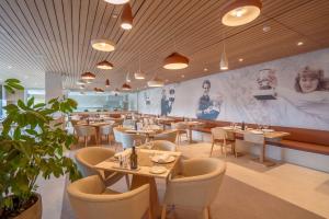a restaurant with tables and chairs and a wall with pictures at Rafa Nadal Residence in Manacor