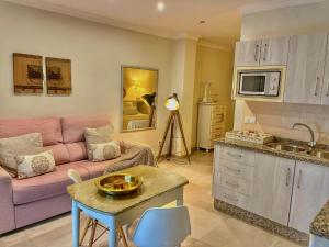 a living room with a pink couch and a table at Hostal Boutique Plaza Cantarero in Nerja