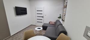 a living room with a couch and a tv at Centrum Apartman LEYLA I in Bardejov