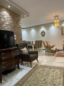 uma sala de estar com cadeiras, uma televisão e uma mesa em Cairo Egypt Al Rehab amazing Flat no Cairo