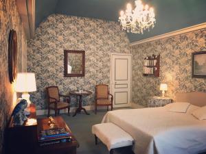 LarçayにあるChambre d'hôte Manoir de Clairboisのベッドルーム1室(ベッド1台、テーブル、椅子付)