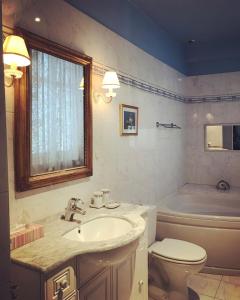 a bathroom with a sink and a toilet and a tub at Chambre d'hôte Manoir de Clairbois in Larçay