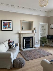 a living room with a couch and a fireplace at Breakwater in North Berwick