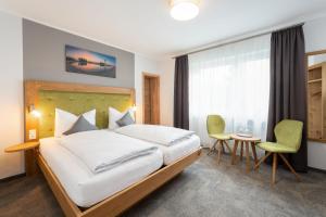 a hotel room with a bed and a table and chairs at Die Landpension FernW in Willingen