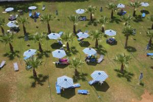 an overhead view of a park with palm trees and umbrellas at Tsokkos Gardens Hotel in Protaras