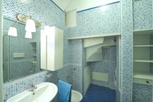 bagno piastrellato blu con lavandino e specchio di Dolce Vita B ad Amalfi