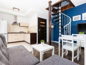 a living room with a couch and a table and a kitchen at Kompleks Wypoczynkowy Pomerania in Rewal