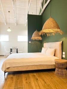 una camera con letto e parete verde di aldea אלדאה a Nir‘am