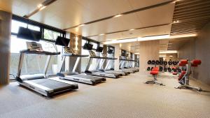 a gym with a row of treadmills and machines at Kloud Hotel in Taichung